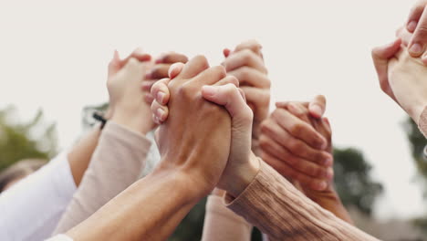 group of diverse people holding hands together