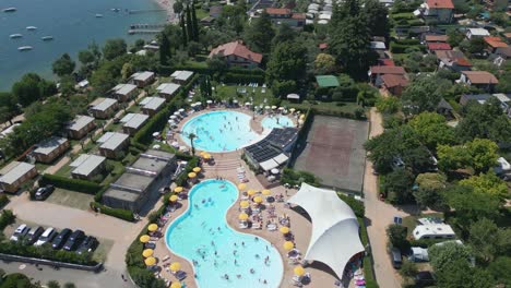 Toma-Aérea-De-La-Piscina-En-El-Camping-Europa-Silvella-Cerca-Del-Lago-De-Garda,-Italia