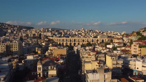 Aerial-reveal-of-beautiful-ancient-roman-aqueduct-in-Kavala,-Greece-at-sunset