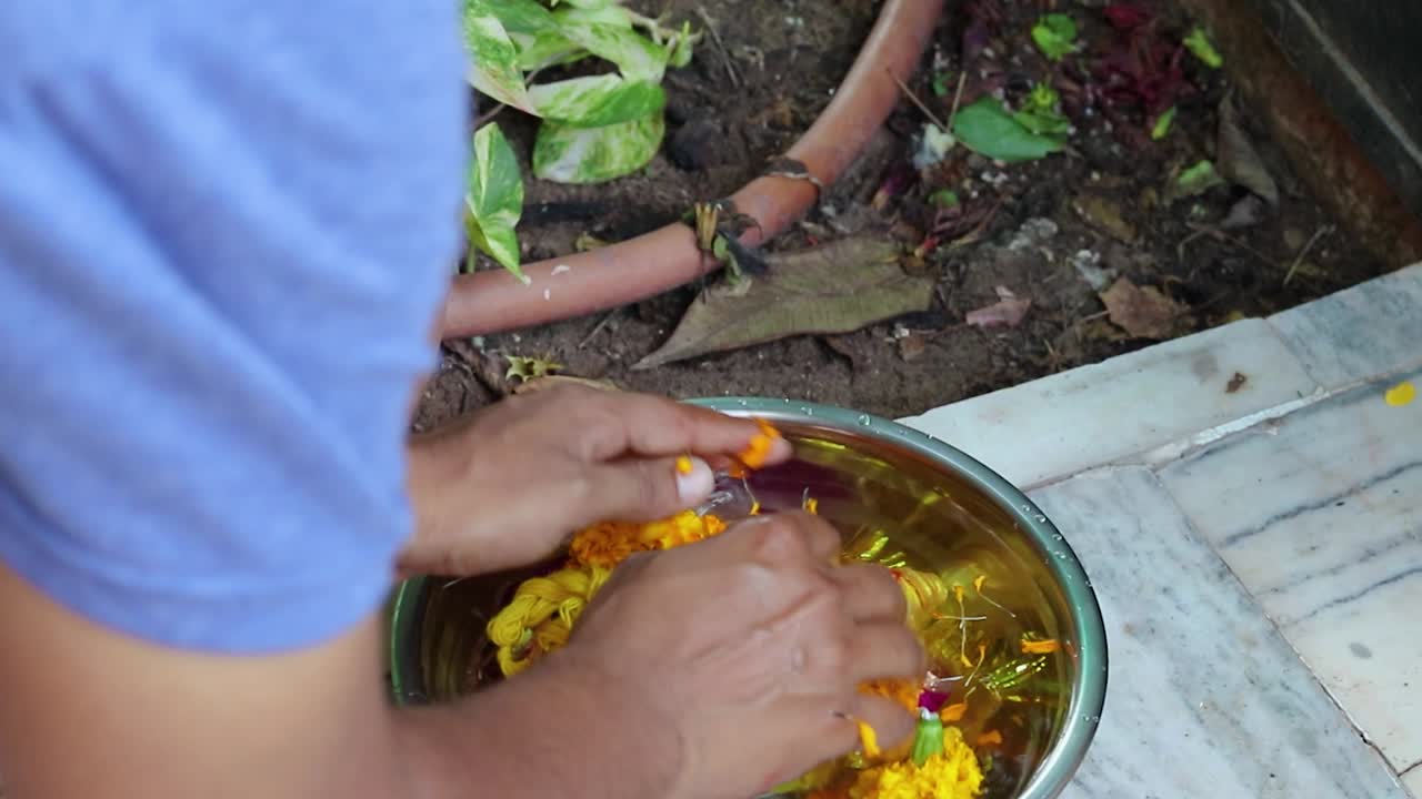 Devoto che esegue l'immersione di Ganpati, del dio sacro indù Ganesha, a casa
