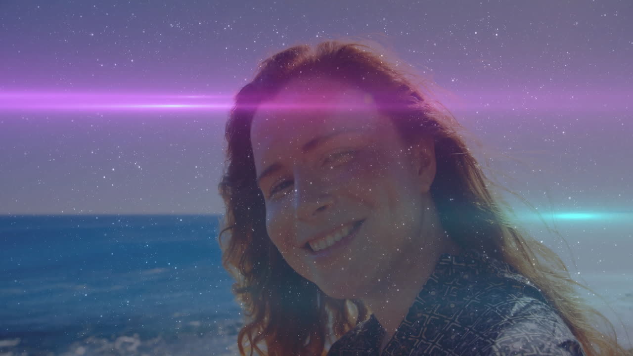 At beach, person with colorful light streaks in animation over ocean background