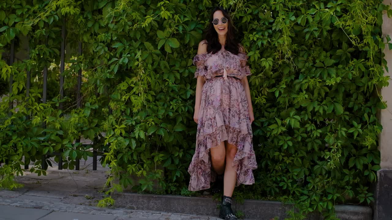 녹색 잎 부시 배경 위에 포즈 세련 된 hipster 소녀