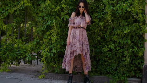 stylish hipster girl posing over green leaves bush background