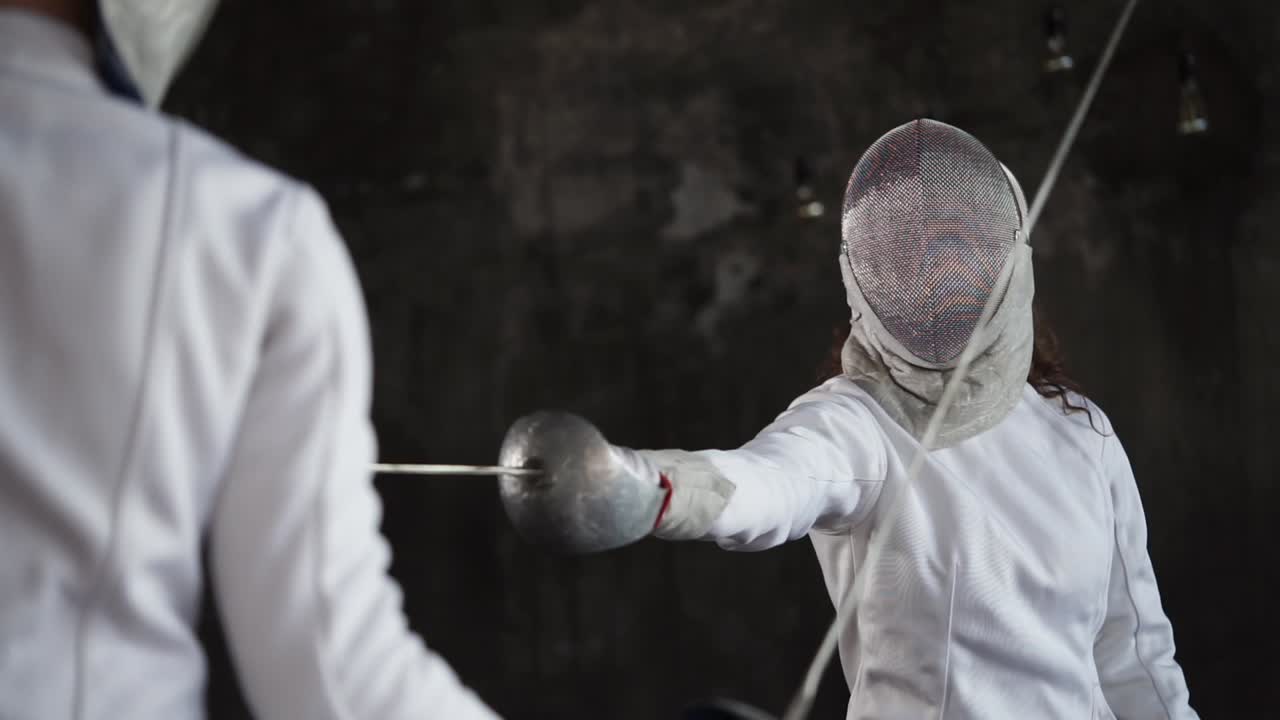 두 명의 펜싱 선수가 행동하고 있습니다.