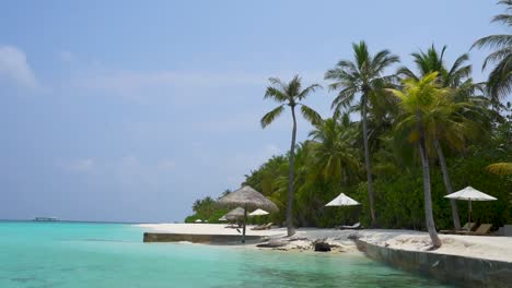 Secluded-Maldives-Tropical-beach-with-palm-trees-calm-water-sand-and-umbrellas