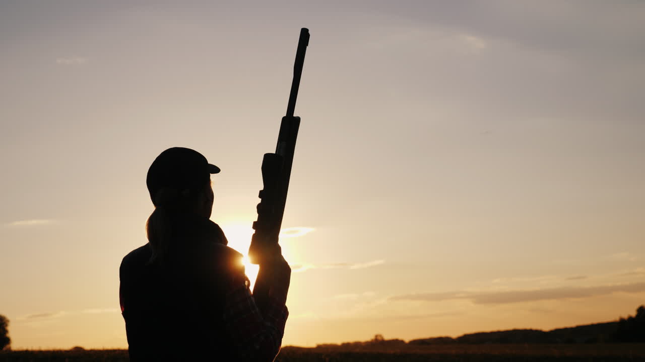 Silhouette Of A Woman With A Rifle In The Rays Of A Sunset Sports Shooting 4K Video