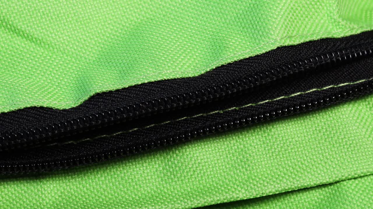 Black zipper opening green textile bag, macro shot 4k
