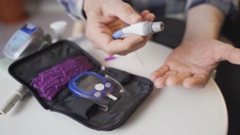 close-up of old man measuring blood sugar.