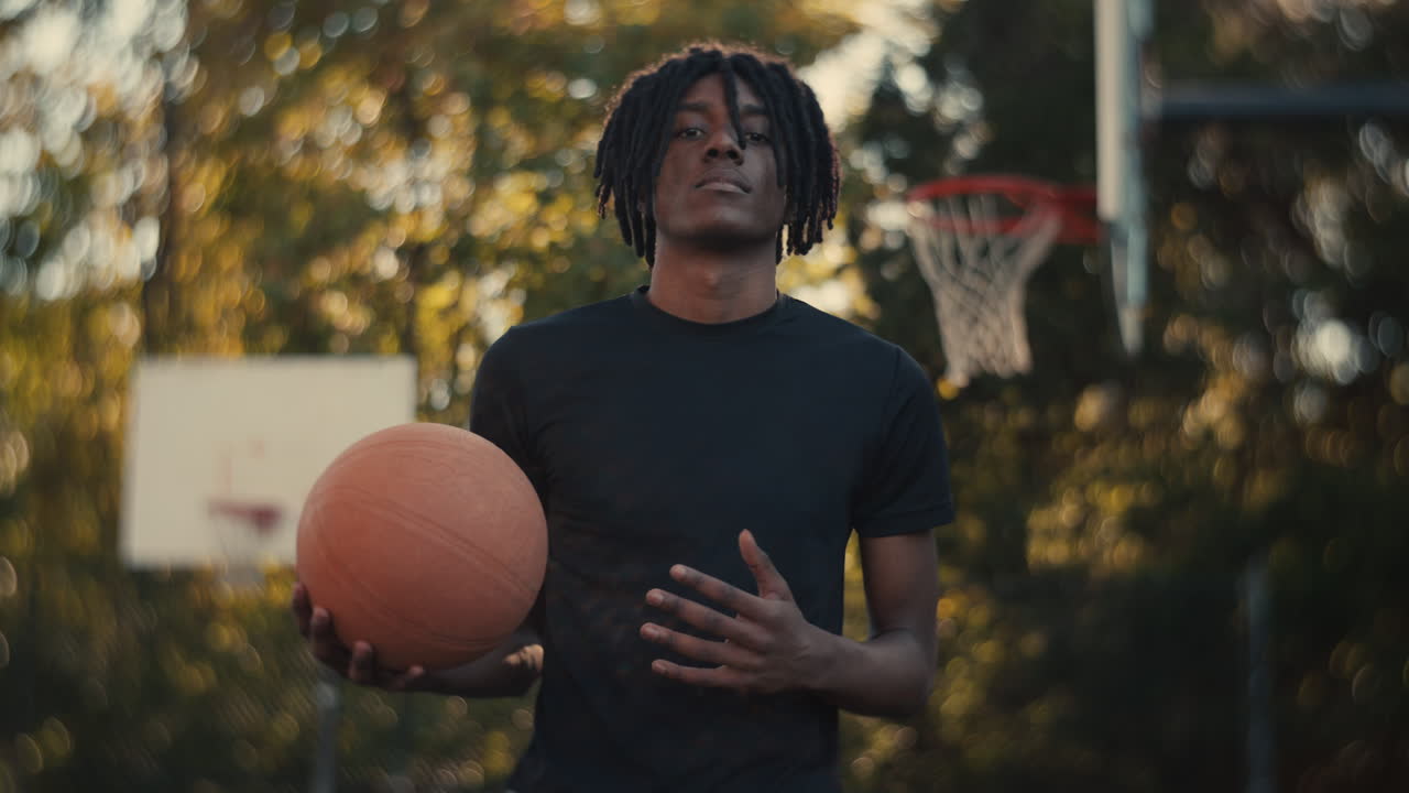 Young Man with Dreadlocks Playing Basketball