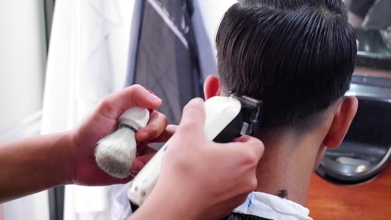 corte de pelo de primer plano en la iluminación oscura de la peluquería