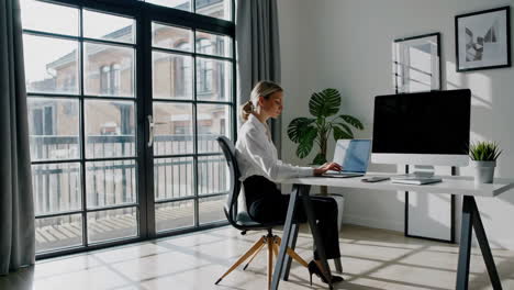 woman working on laptop at a desk in a modern office