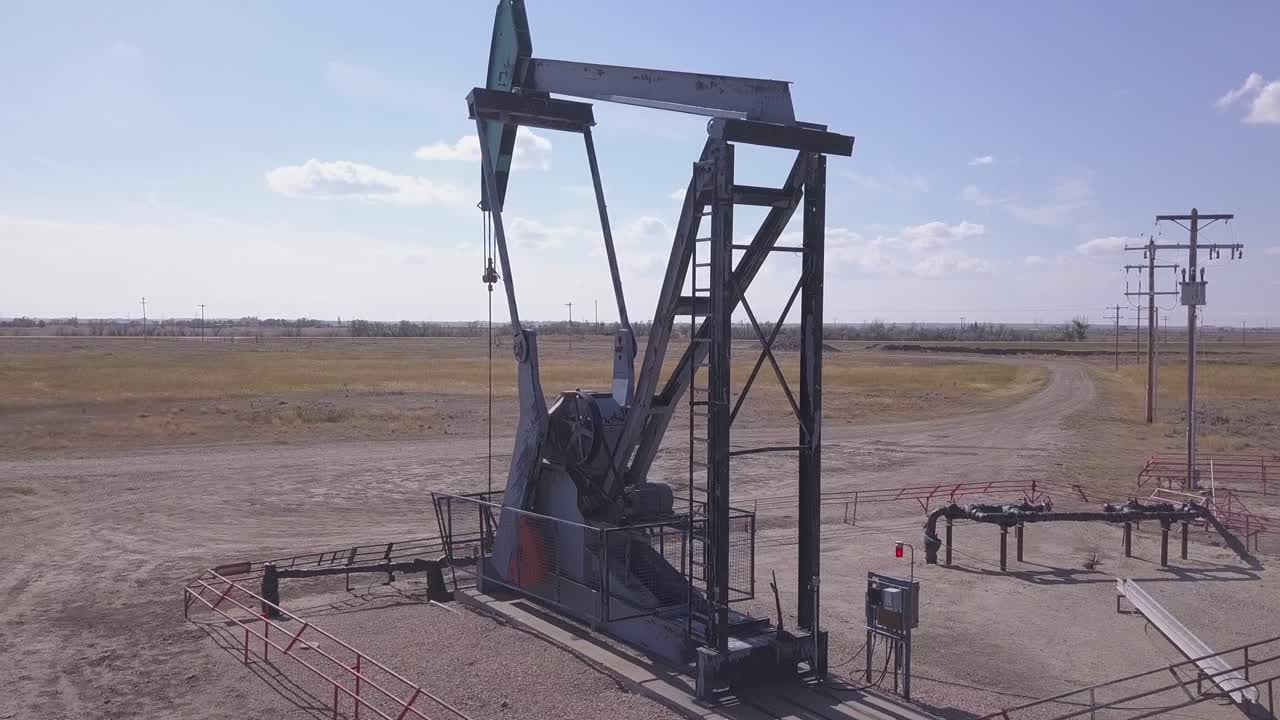 órbitas aéreas pumpjack asno asintiendo bombeando petróleo crudo en las llanuras