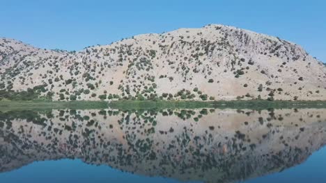 Lago-Kournas-En-Creta-Imágenes-De-Drones-Bajos-Con-Gran-Reflejo-En-El-Agua