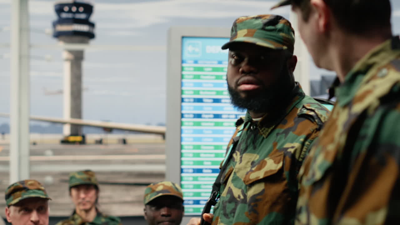 Soldati di una squadra militare che attraversano un affollato corridoio del terminal aeroportuale, in viaggio verso casa.