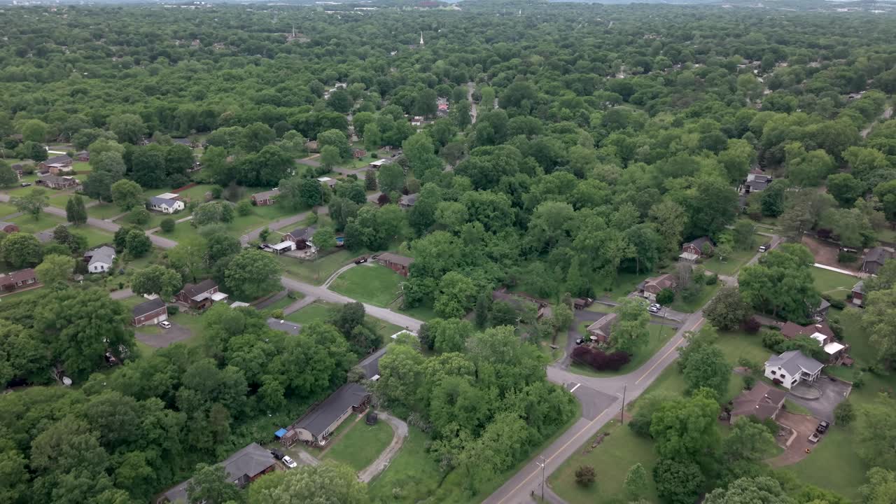 A beautiful aerial view of a suburban Nashville area surrounded by lush green vegetation. push forward
