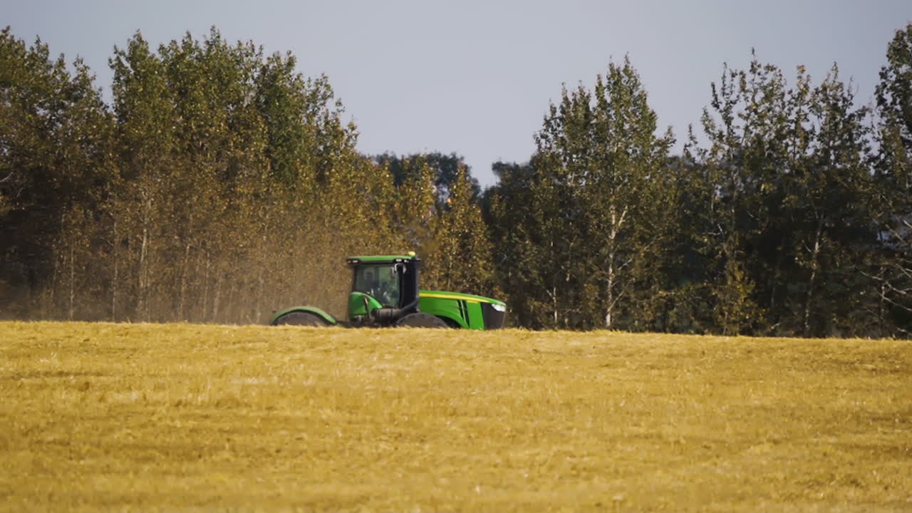 Tractor Working On The Wheat Field In Red Deer County, Alberta, Canada - Wide Shot