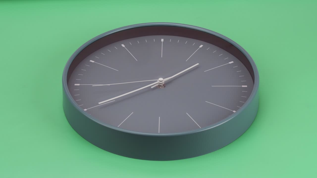 Orologio da parete grigio su sfondo verde