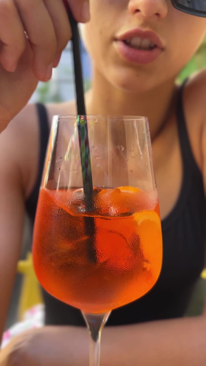 una mujer disfrutando de un aperol spritz.