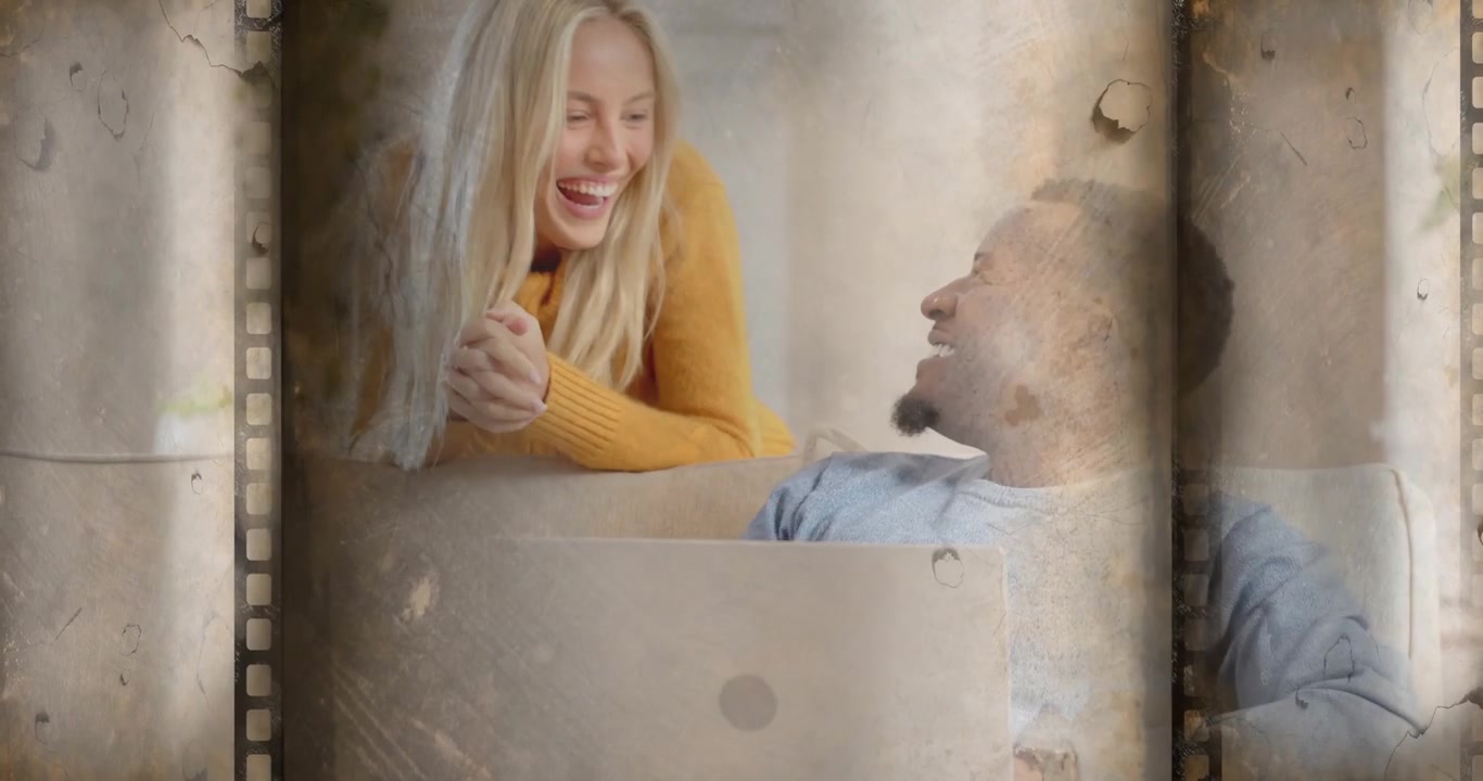 Uomo concentrato sul laptop in un ambiente tecnologico, quando una donna si avvicina al divano, si appoggia e inizia una conversazione calorosa.