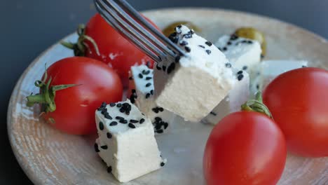 plate of cheese, tomatoes, and sesame seeds