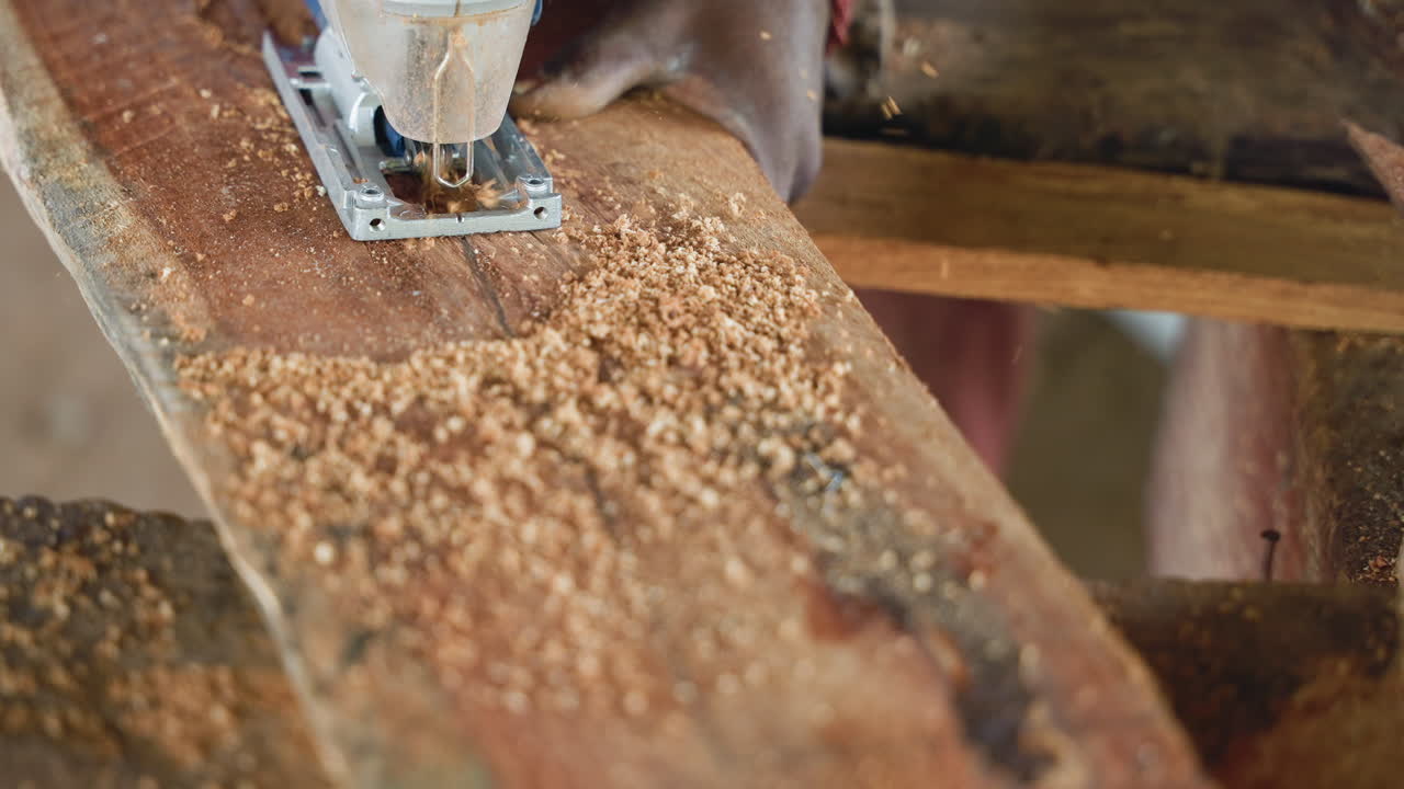 Closeup jigsaw cutting reclaimed wood plank, artisan shaping surface with steady motion, dense sawdust scattering across workbench, blade skimming grain for furniture component, focused workshop
