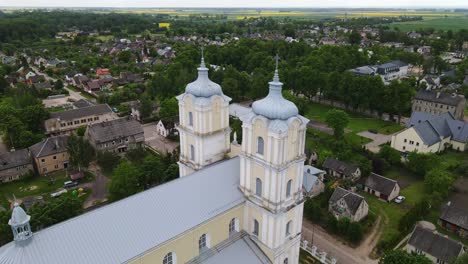 baroque-style lithuanian church towers rise above village homes, orbiting drone