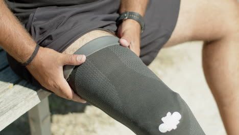 close-up of man with disability fixing below knee prosthesis