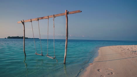 Cinemagraph-Nahtlose-Videoschleife-Einer-Holzschaukel-An-Einem-Tropischen-Abgelegenen-Traumstrand-Für-Die-Flitterwochen-Am-Meer-Auf-Einer-Leeren-Natürlichen-Abenteuerinsel-In-Indonesien-Mit-Weißem-Sand-Bei-Sonnenuntergang