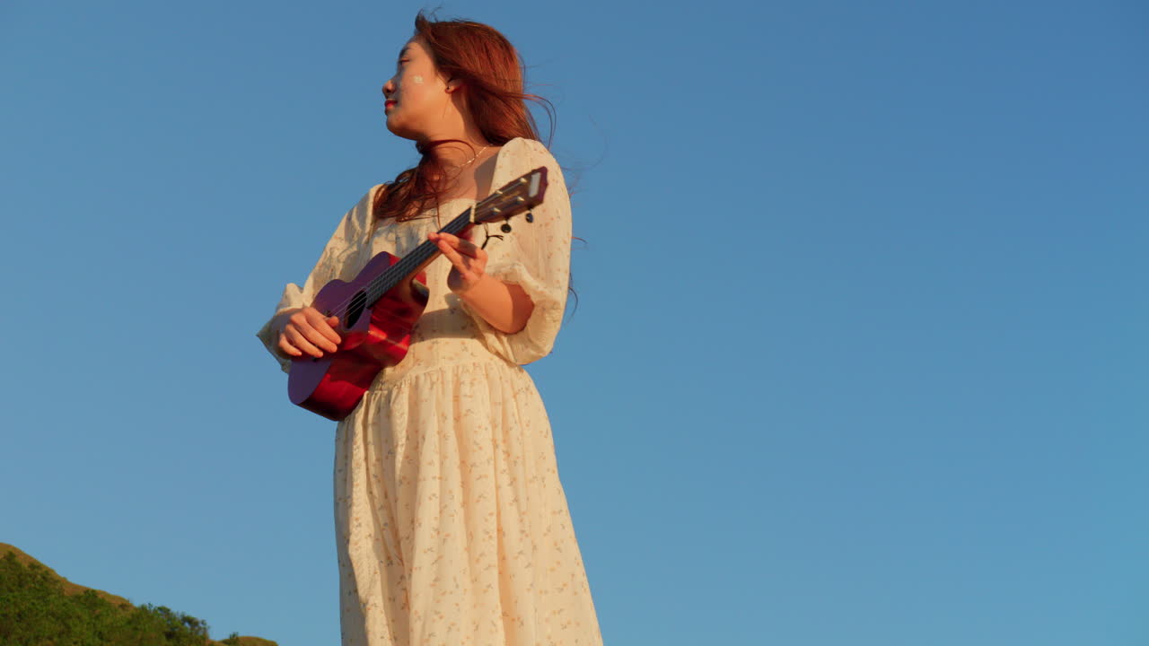 Woman playing ukulele in a field