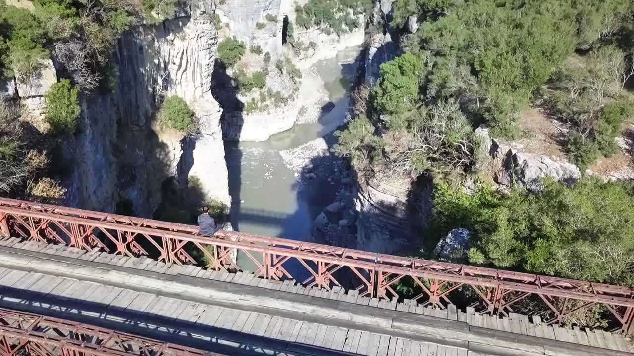 다리 위에 앉아 도로 여행의 아름다운 풍경을 즐기고 있는 남자