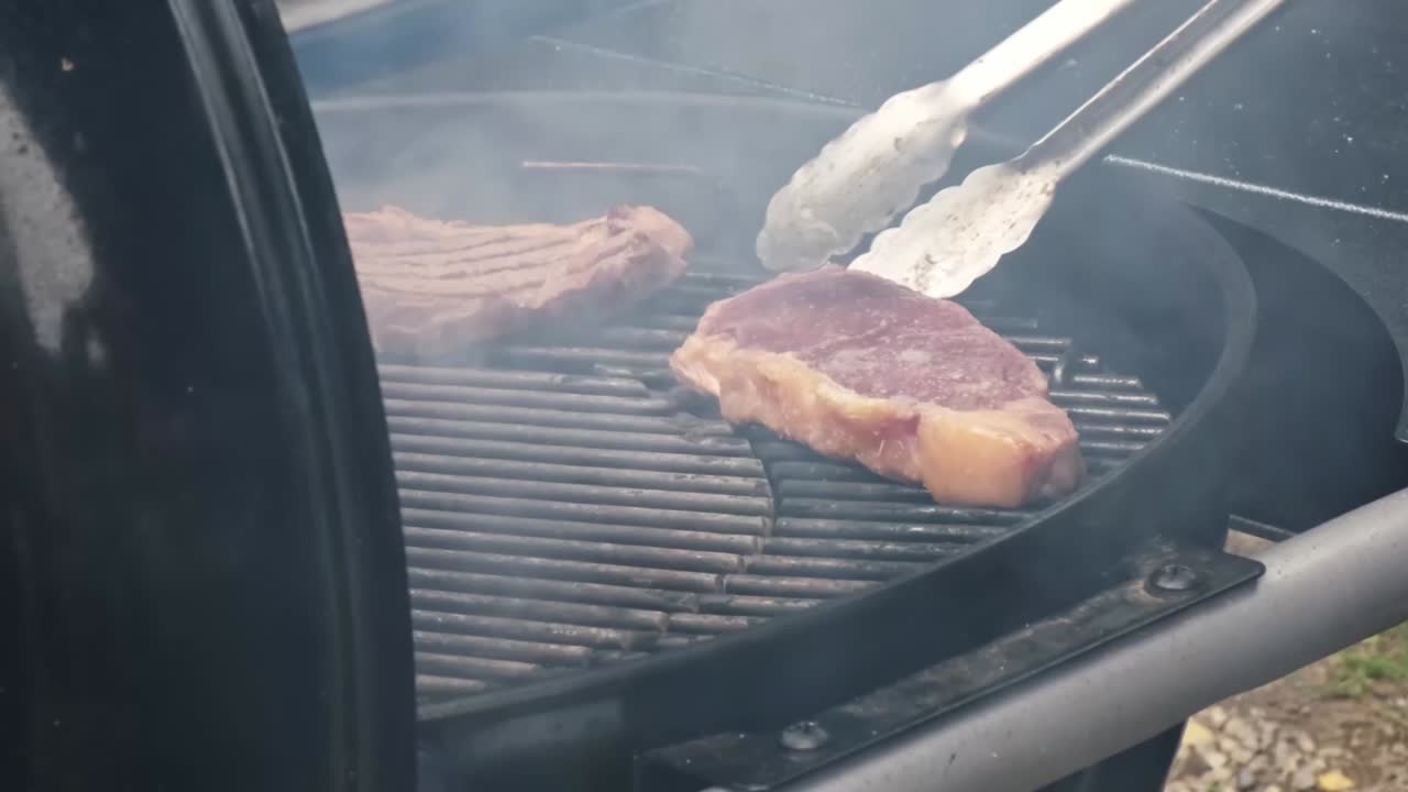 The steak is turned over on the grill.