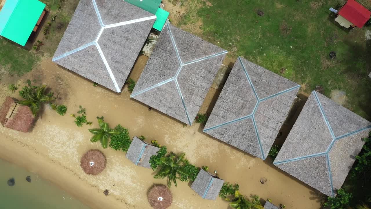 toma cinematográfica, vista aérea de drones de un resort en la costa, playa de arena blanca, bungalows en roxas, palawan