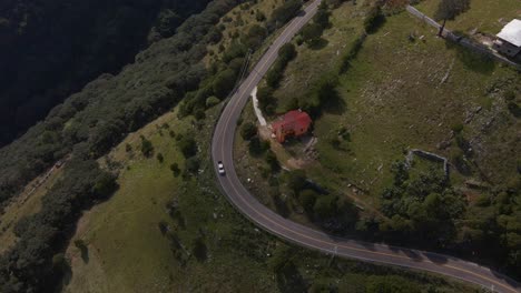 Car-driving-on-rural-paved-curved-road,-aerial-top-down-view-Central-Mexico