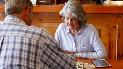 Friends-playing-chess-while-having-glass-of-beer-in-bar-4k