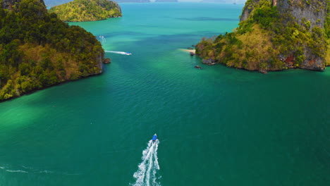 drone siguiendo un bote de cola larga conduciendo hacia pequeñas islas verdes, antena