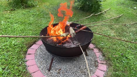 Medium-shot-of-grilling-stick-bread-and-sausages-during-the-EM-2024-in-the-garden