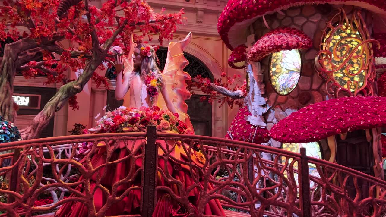 벨라지오 호텔과 카지노의 요정 정원에서 꽃으로 둘러싸인 다리에 서 있는 나비 여왕