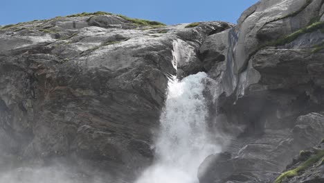 waterfall in the swiss alps during a sunny day, cascade creates humidity and fog, wallis