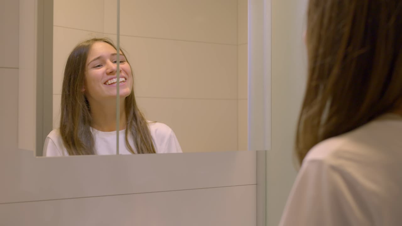mujer alegre mirando en el espejo del baño, completa incredulidad