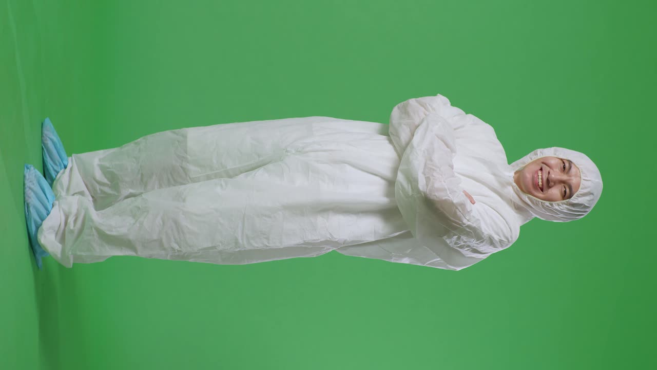 녹색 스크린 배경에서 팔을 고 미소 짓는 아시아 남성 과학자의 전체 몸의 측면 시각