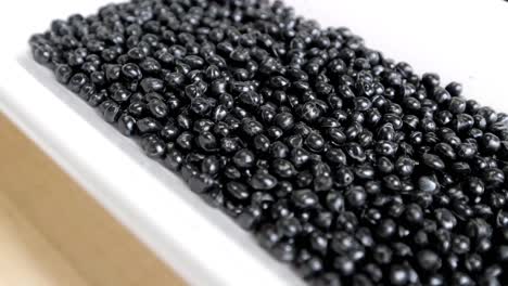 black polymer granules in a garbage recycling plant. raw materials for recycled plastic are used in manufacturing.