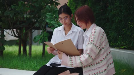 two teen girls studying outdoors