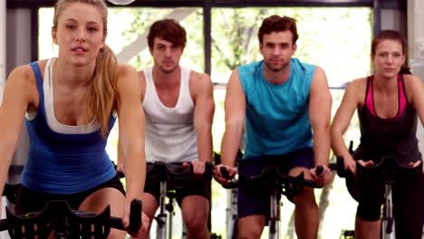 fit group of people using exercise bike together