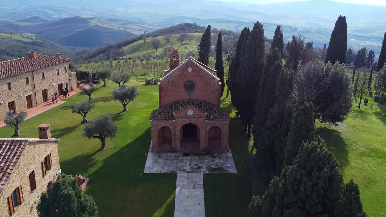 stunning aerial view of Montecucco, Tuscany. Footage captures the facade of a historic church with vineyards in the background, showcasing the region’s rich heritage and breathtaking landscapes.