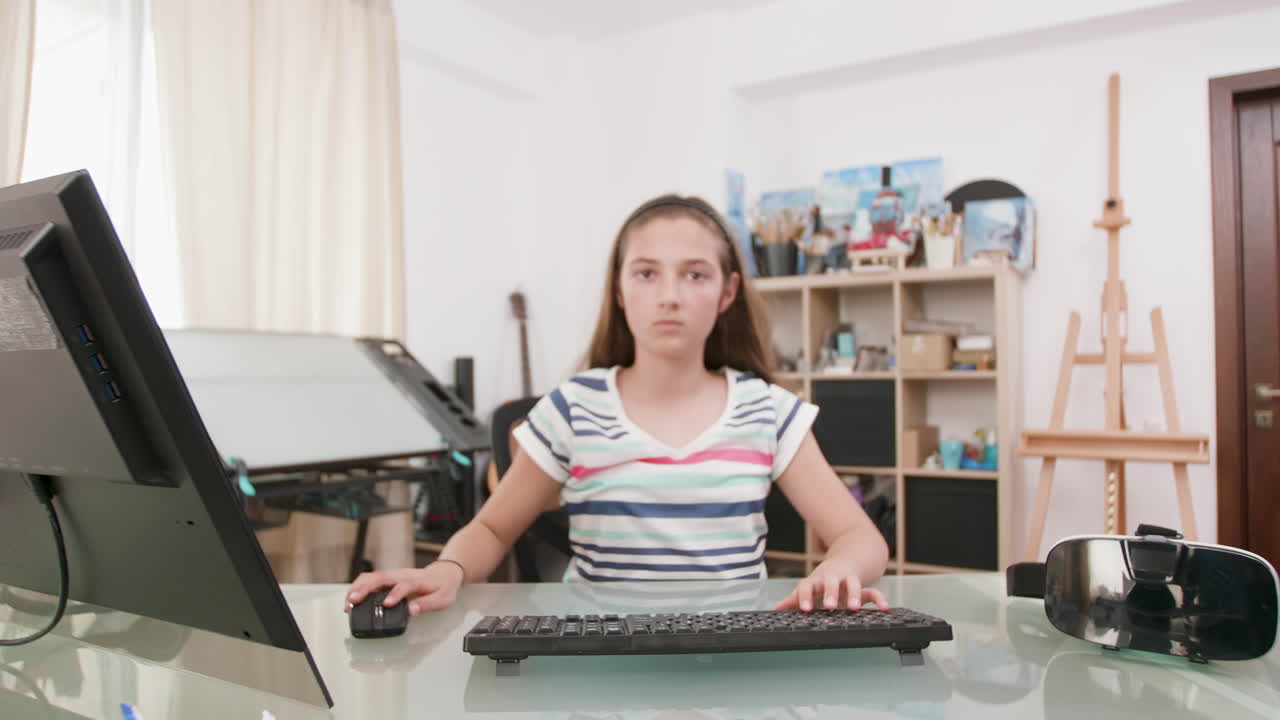 Girl working at computer desk at home
