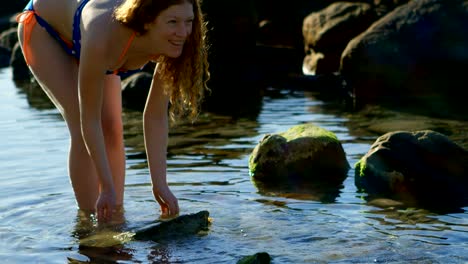 mujer jugando con agua en la playa 4k