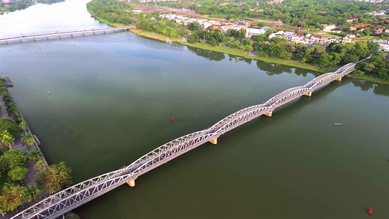 Historical bridge crossing Perfume River in Hue, Vietnam under warm morning light