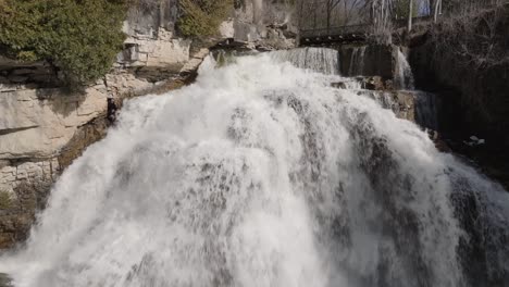 rushing waterfall at owen sound, ontario with lush rocky surroundings in daylight