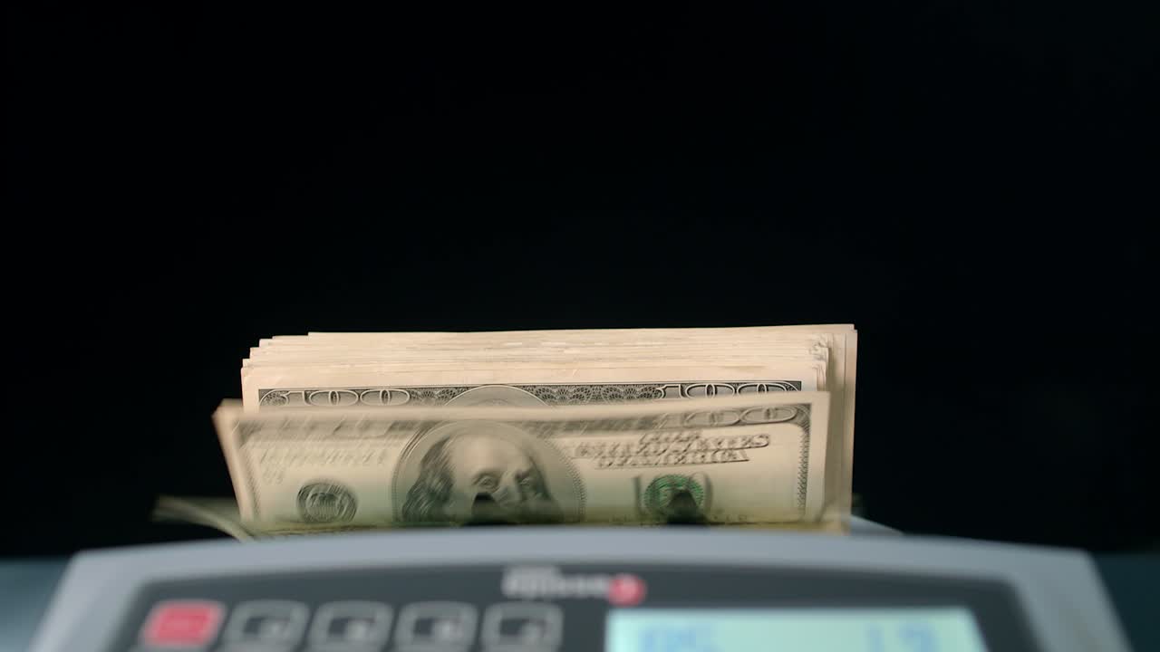 Banknote counter counting dollar bills. Money counting machine. Business success