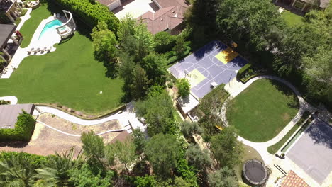 Aerial-shot-of-resort-in-the-city-with-basketball-court-and-swimming-pool